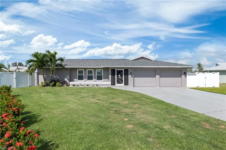 Ranch-style home featuring 2 car garage and a front lawn
