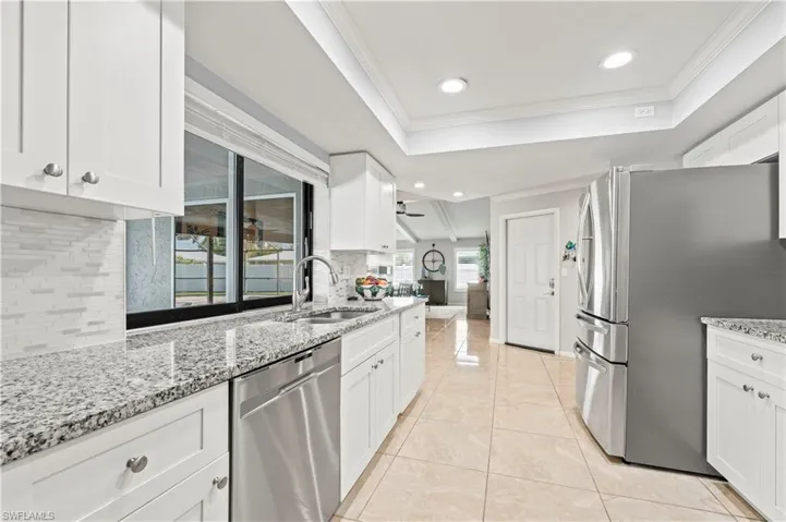 Kitchen with white cabinets, appliances with stainless steel finishes, and tasteful backsplash