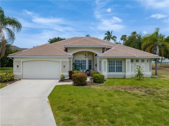 Ranch-style house featuring a garage and a front lawn