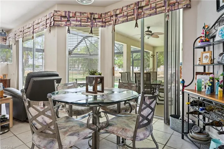 Tiled dining room featuring a wealth of natural light and ceiling fan