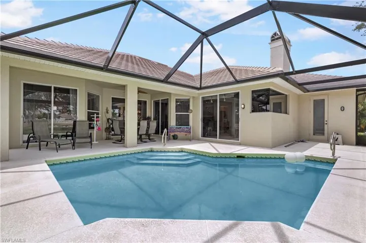 View of swimming pool with a lanai and a patio area