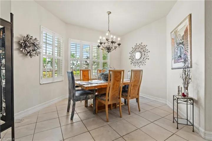 Tiled dining room with a chandelier
