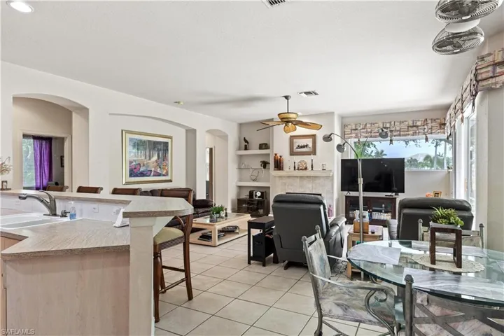 Dining area with built in features, ceiling fan, sink, and light tile floors