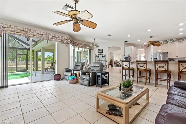 Tiled living room featuring plenty of natural light and ceiling fan