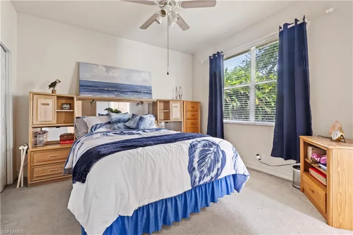 Bedroom with ceiling fan and light carpet