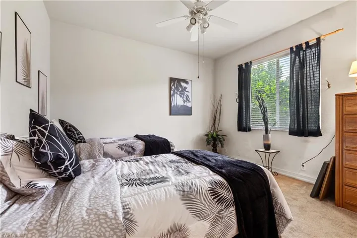 Bedroom with ceiling fan and light colored carpet