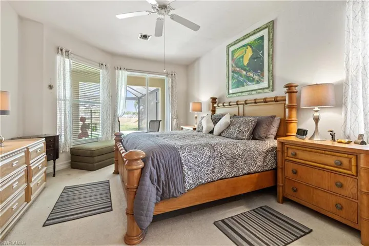 Bedroom with ceiling fan, multiple windows, and light carpet
