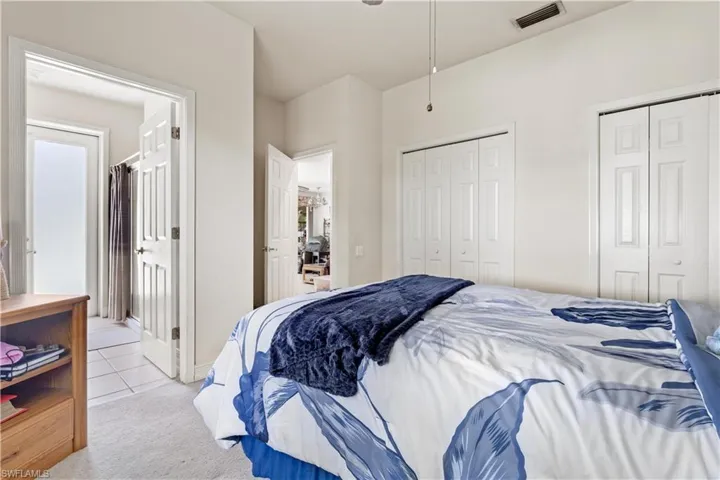 Carpeted bedroom featuring multiple closets