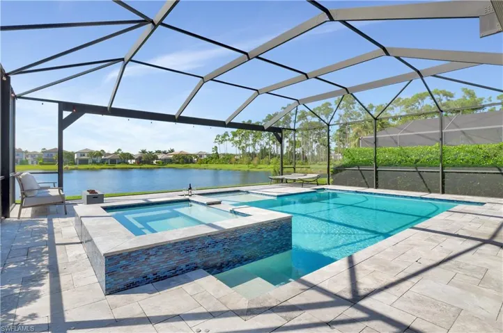 View of pool featuring a lanai, a water view, and an in ground hot tub