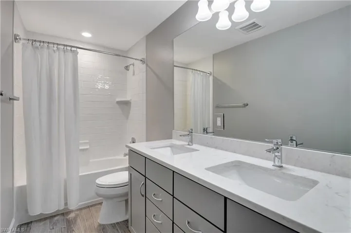 4th Full bathroom with vanity, toilet, shower / tub combo, and hardwood / wood-style flooring