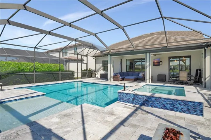 View of pool with a lanai, an outdoor hangout area, and a patio area