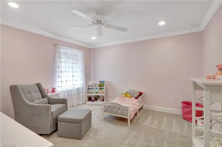 5th bedroom featuring ceiling fan, ornamental molding, and carpet floors