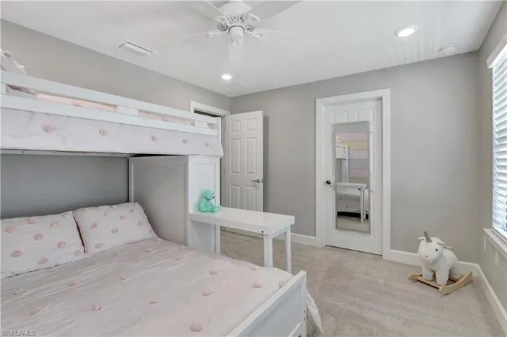 4th Bedroom featuring light carpet, multiple windows, and ceiling fan