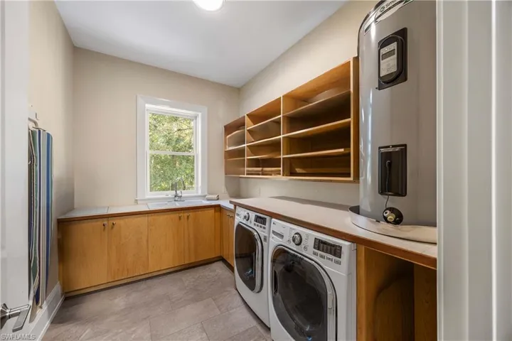 Laundry room with slop sink, ironing board and counter for folding laundry.