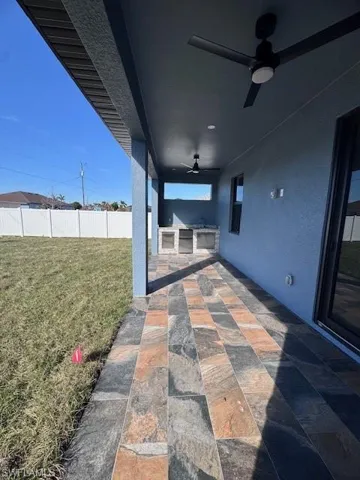 View of patio featuring area for grilling and ceiling fan