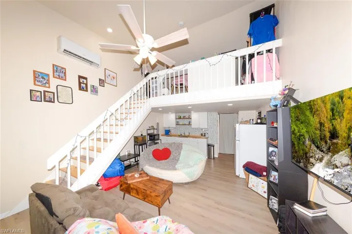 Living area with light wood-style floors, recessed lighting, a high ceiling, and a ceiling fan