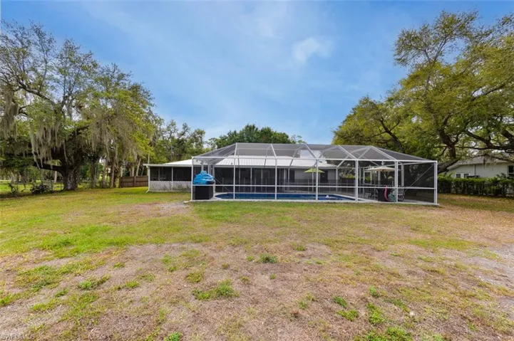 Fenced backyard with glass enclosure and a sunroom