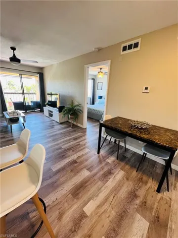 Living room featuring wood finished floors, ceiling fan, and baseboards