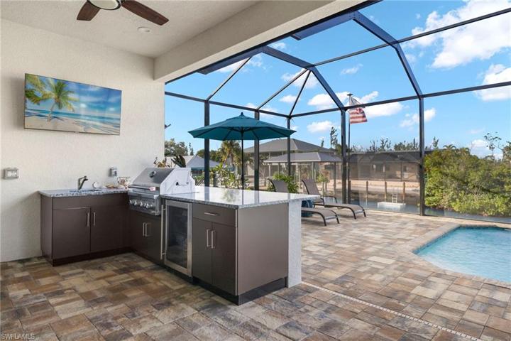 Why cook inside when you have this amazing outdoor kitchen with grill (never used), wine fridge, sink and storage?  The cabinets are powder coated and easily withstand the outdoor summer weather.  Kick back and watch the games from the pool and live your best life in beautiful SWFL!