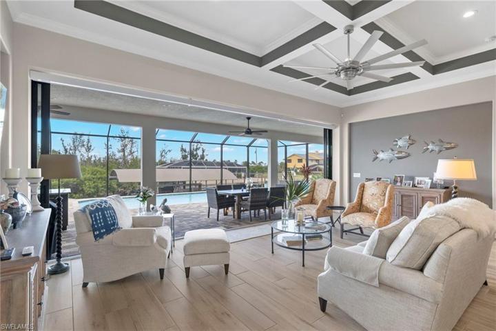 View from the great room towards the pool/outdoor area and dock.  Owners spared no expense when adding details to maximize the quality of both the home and quality of life.  Noseeum pool cagetoo.... no pesky nats here!
