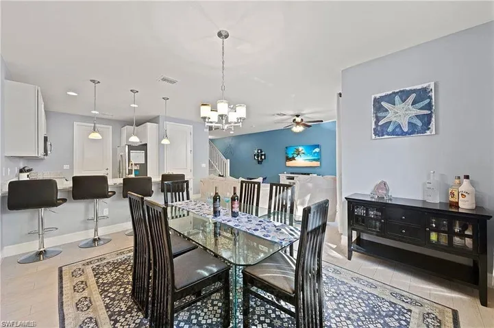 Dining room featuring baseboards, visible vents, and ceiling fan with notable chandelier