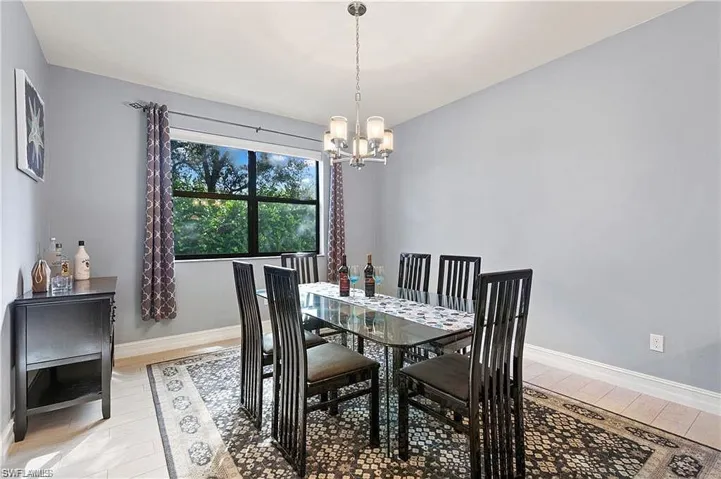 Dining room with baseboards, a notable chandelier, and light wood-type flooring