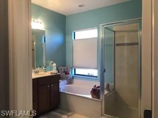Bathroom featuring dual sink vanity and independent shower and bath
