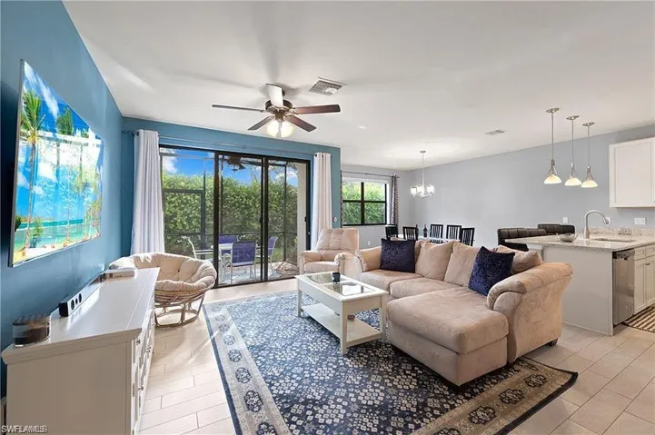 Living room with sliding doors to enclosed lanai overlooking private back yard.