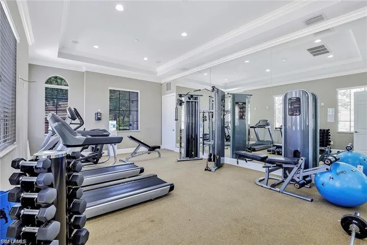Gym featuring crown molding and a tray ceiling