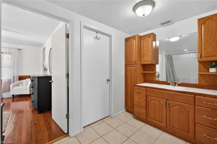 Kitchen with wood finish cabinetry, open shelves, and tile countertops