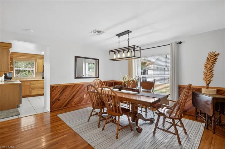 Dining area featuring wooden walls, wainscoting, plenty of natural light, and light wood-type flooring