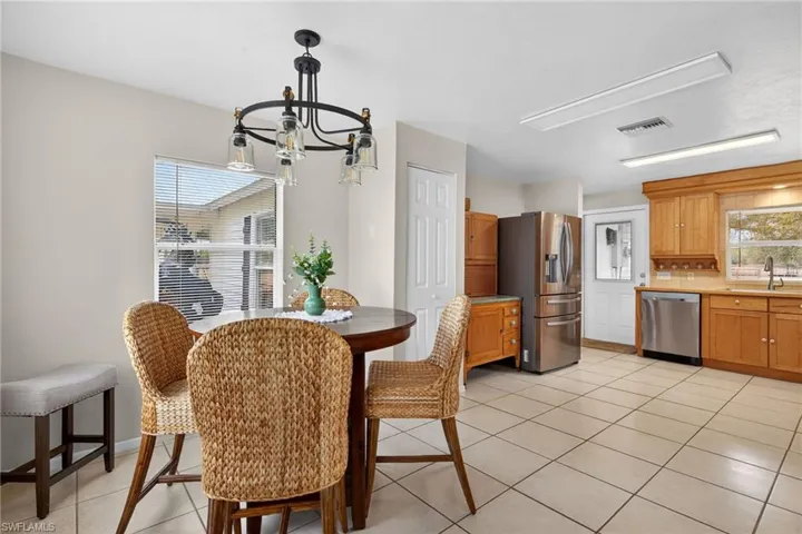 Dining area with light tile patterned flooring and hanging lights
