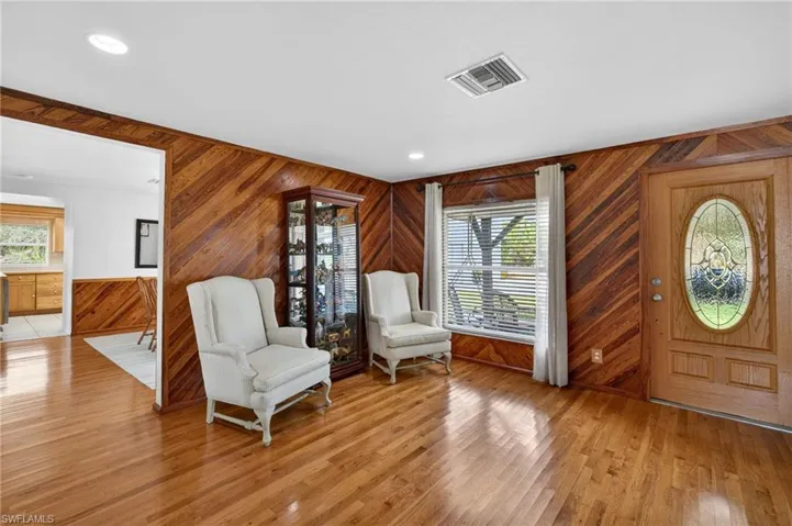 Entrance foyer featuring wooden walls, light wood-style flooring, and recessed lighting