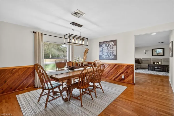 Dining area with wood walls, wainscoting, and light wood-type flooring