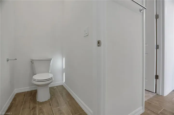 Bathroom with wood tiled floors and toilet