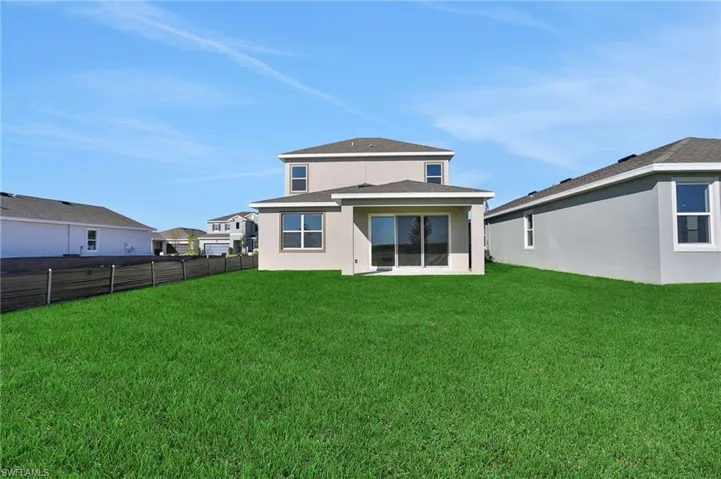 Rear view of house featuring stucco siding and a patio area