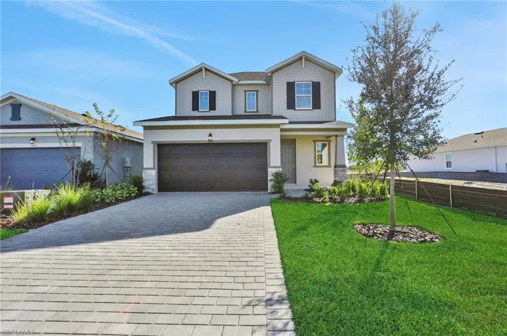 Craftsman-style house with a garage, decorative driveway, stone siding, and stucco siding