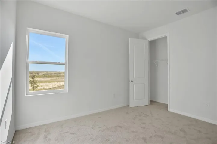 Unfurnished bedroom with light colored carpet and a closet
