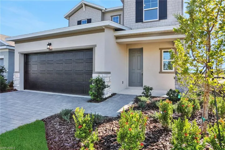 View of front of home with driveway, stucco siding, and a garage