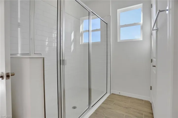 Bathroom featuring a shower stall and wood tiled floors