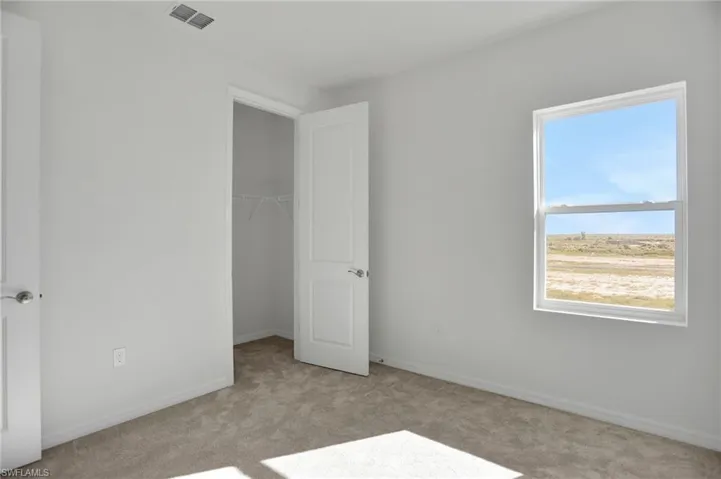 Unfurnished bedroom featuring carpet flooring and a spacious closet