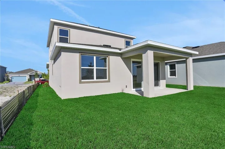 Back of house with stucco siding and a patio area