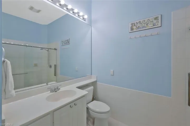 Bathroom with visible vents, toilet, a stall shower, and vanity