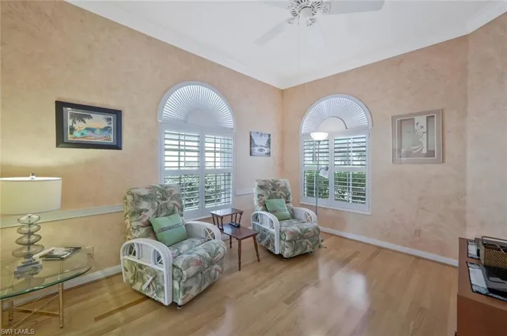 Living area featuring wood finished floors, ceiling fan, baseboards, and plenty of natural light