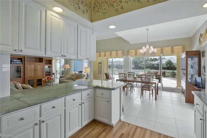 Kitchen featuring ornamental molding, white cabinets, and an inviting chandelier