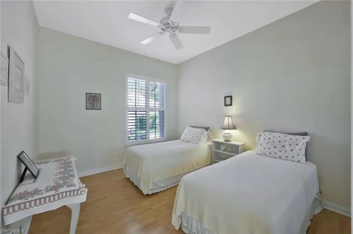 Bedroom featuring light wood-style floors, baseboards, and ceiling fan
