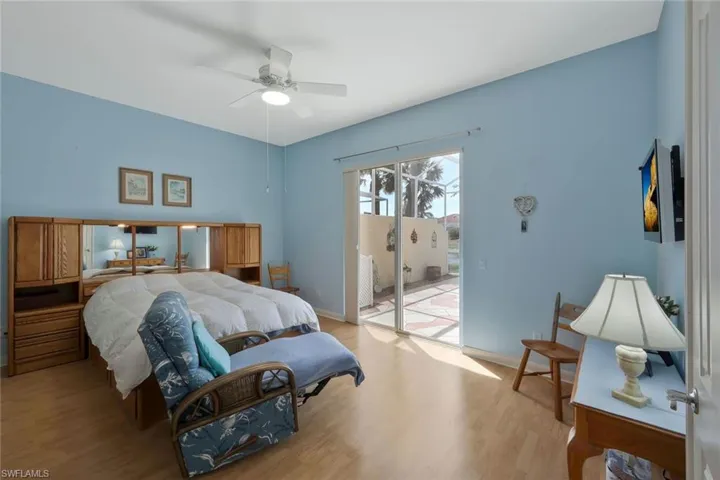 Bedroom with light wood-type flooring, access to exterior, baseboards, and a ceiling fan