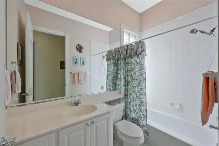 Bathroom with shower / tub combo, vanity, and toilet