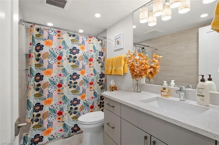 Bathroom with vanity, recessed lighting, and curtained shower