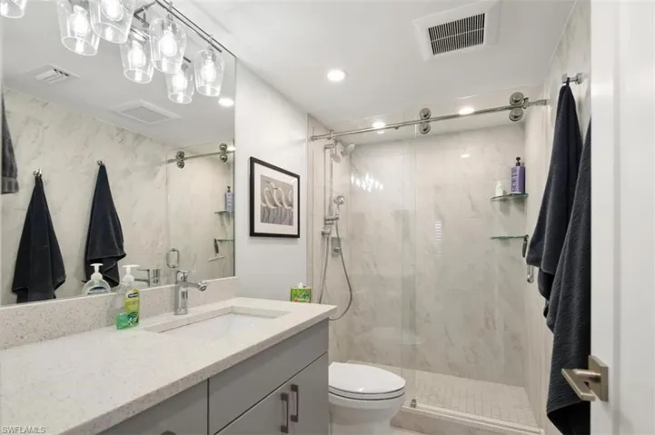 Full bathroom featuring vanity, a stall shower, and recessed lighting